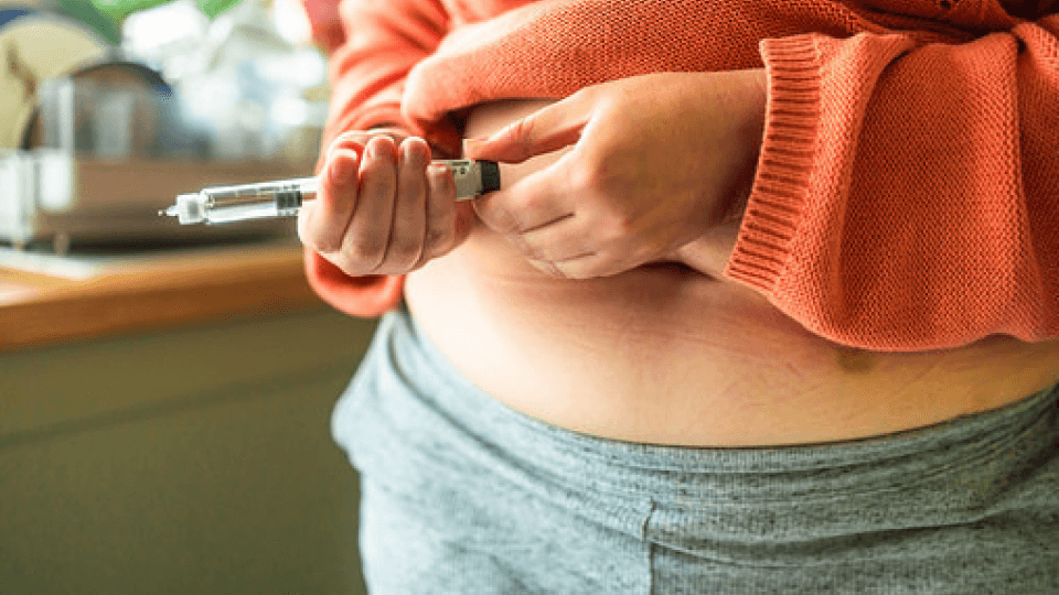 A woman injecting Mounjaro into her abdomen