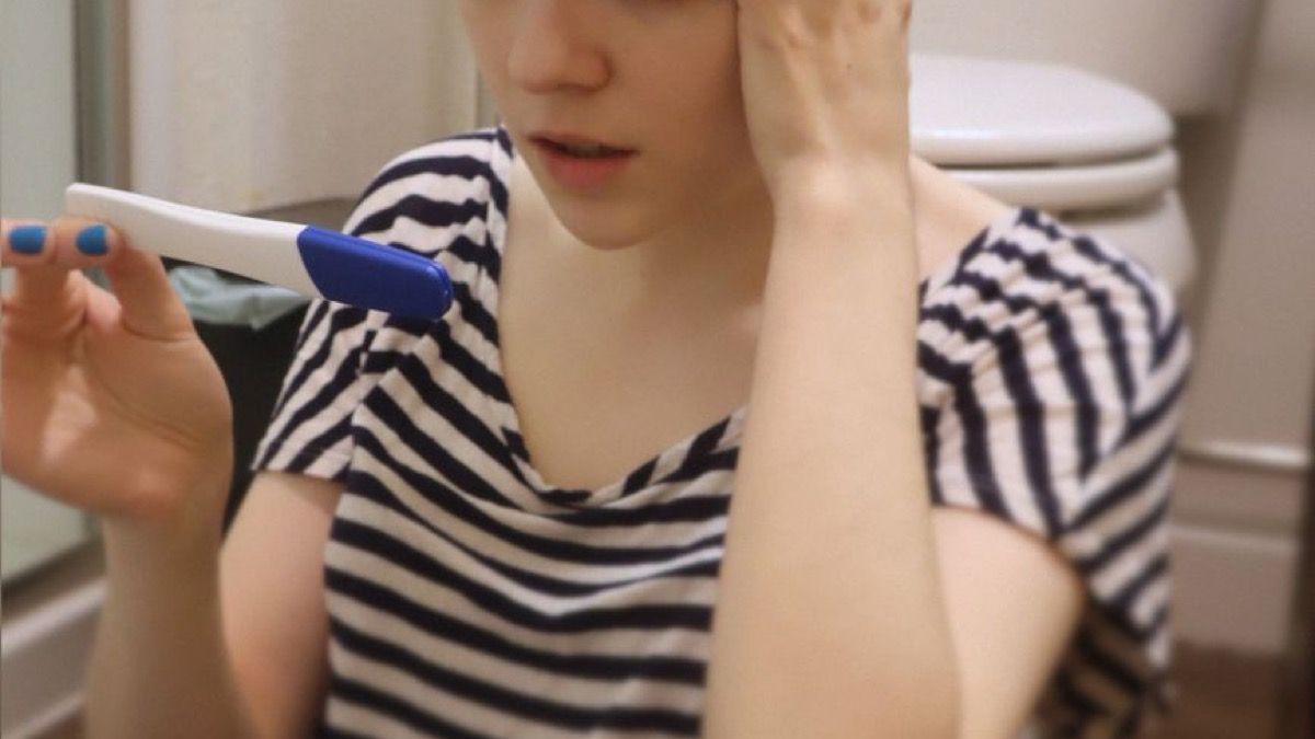 화장실에서 소변 색을 확인하며 걱정하는 여성