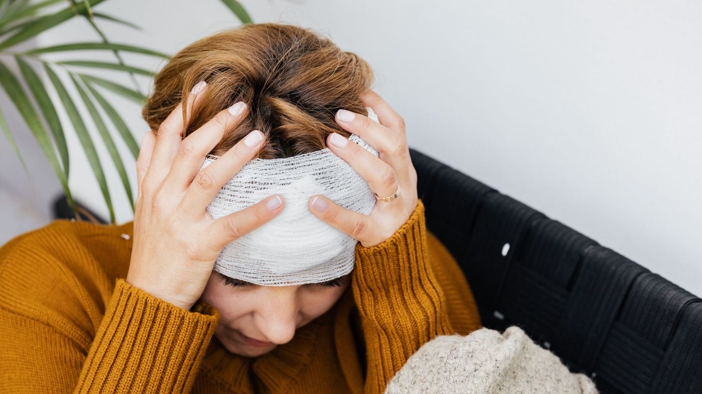 person with mild headache resting at home