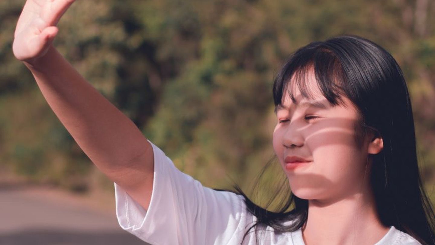 햇볕이 내리쬐는 야외에서 팔을 가리는 모습