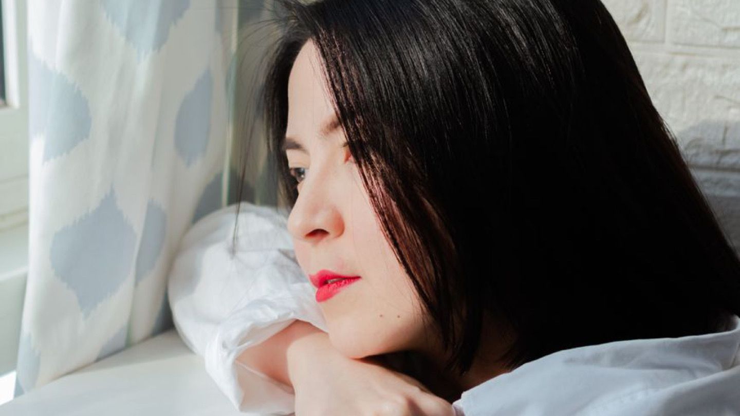 창가에 턱을 괴고 기운 없이 밖을 보는 사람