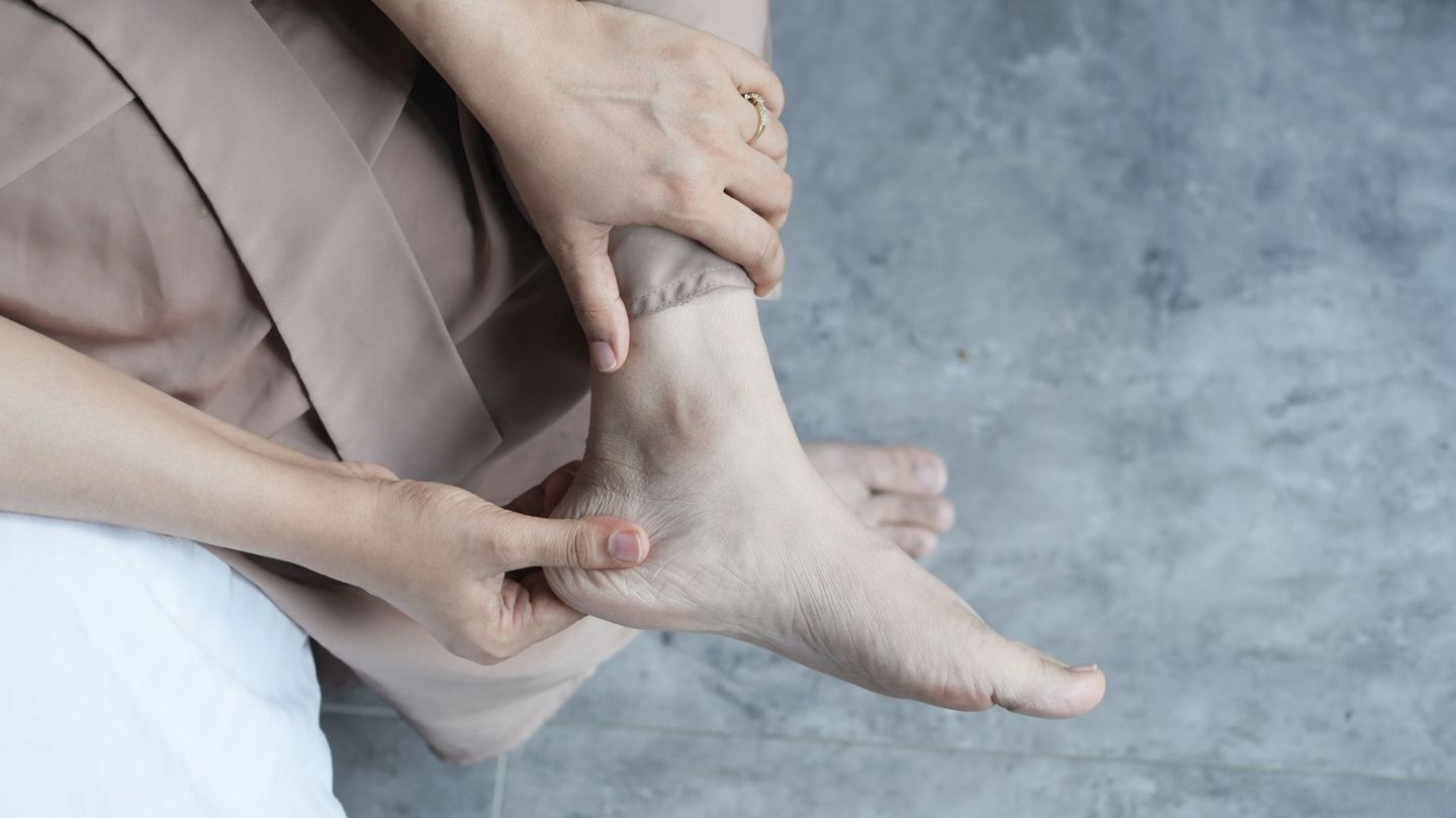 발 저림을 호소하며 발을 만지는 중년 남성