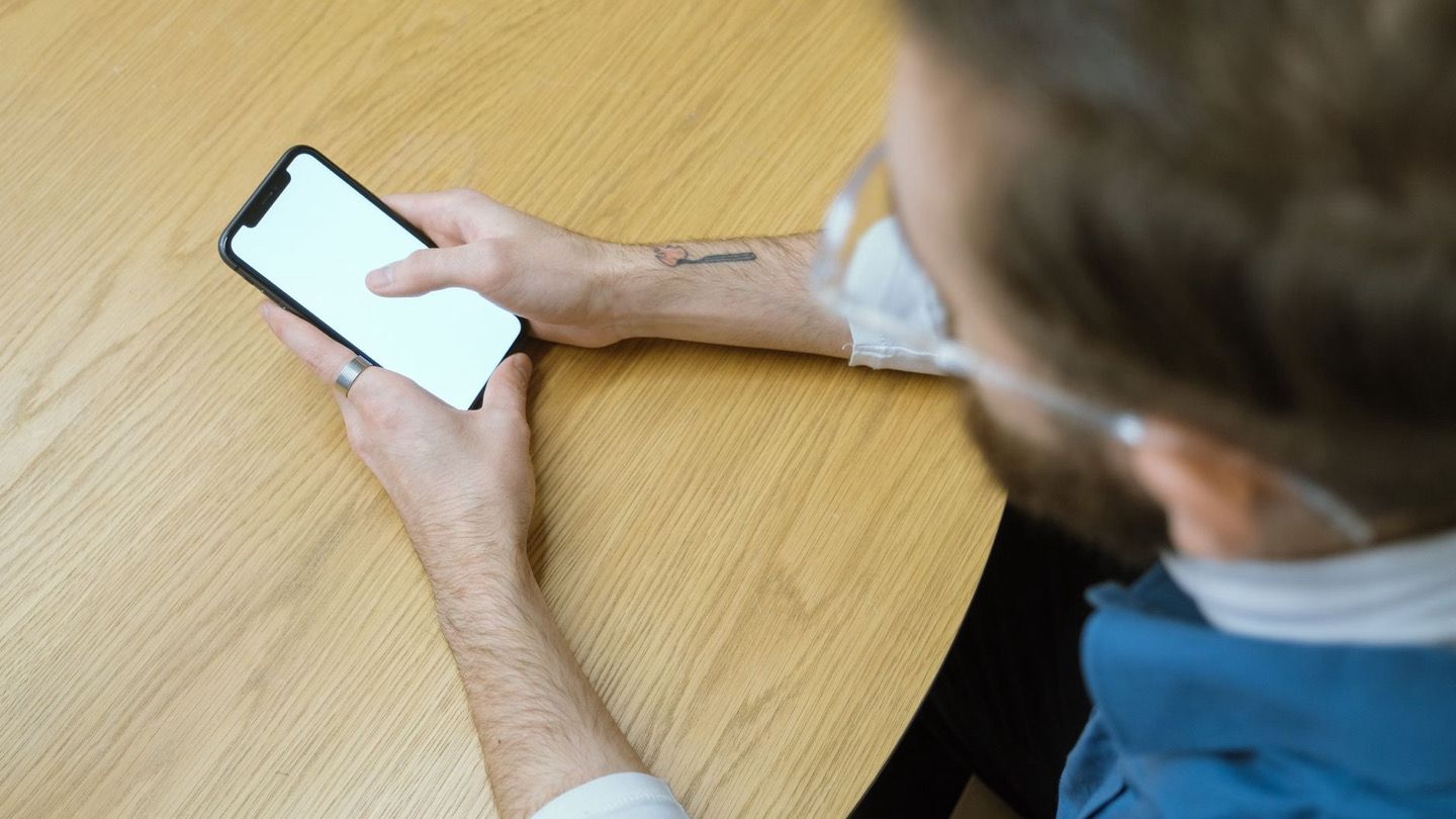 person checking time on phone before taking medicine